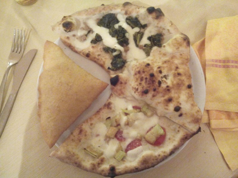 Degustazione Lo Scugnizzo: spicchi di pizza con verdure scure, zucchine, pomodorini e un triangolo fritto nel piatto